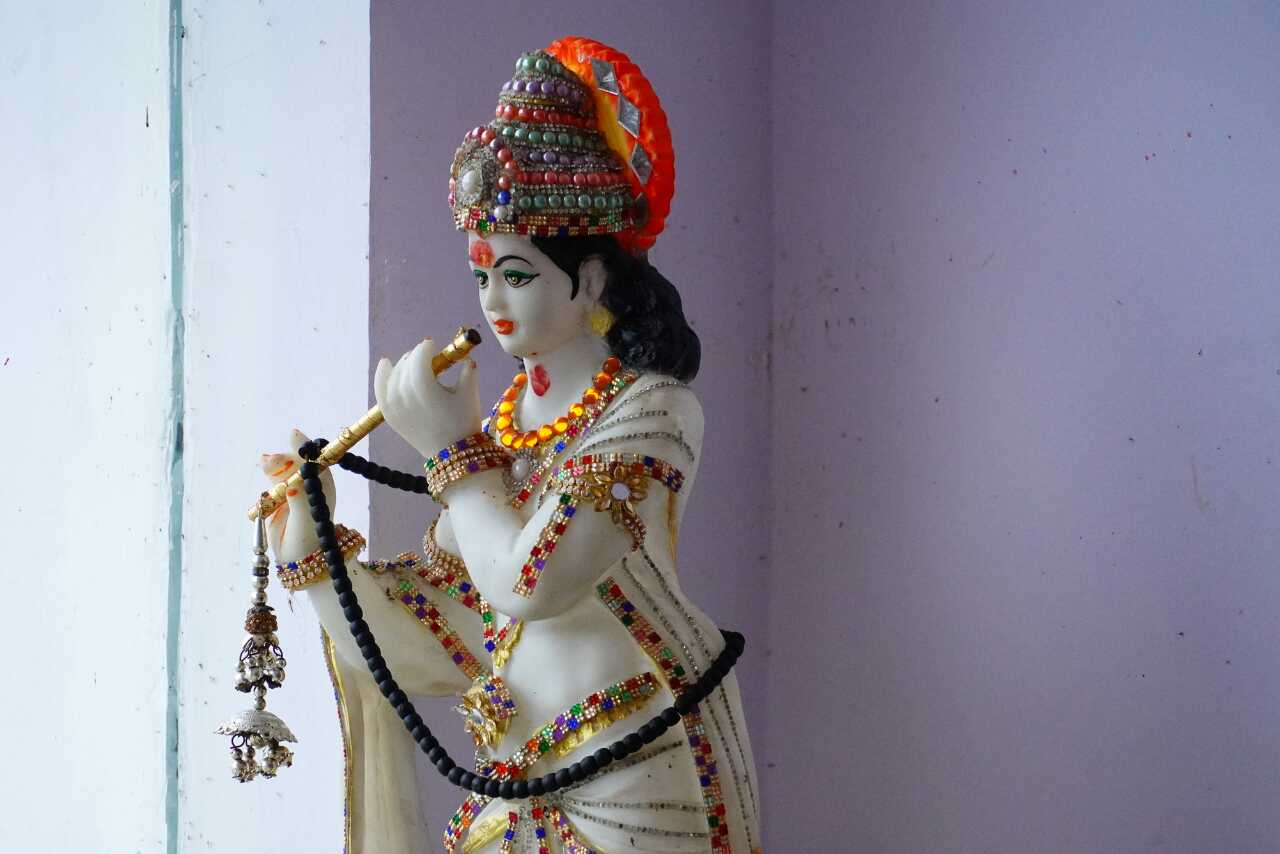 Beautiful white statue of Lord Krishna with a flute, perfect for devotional spaces.